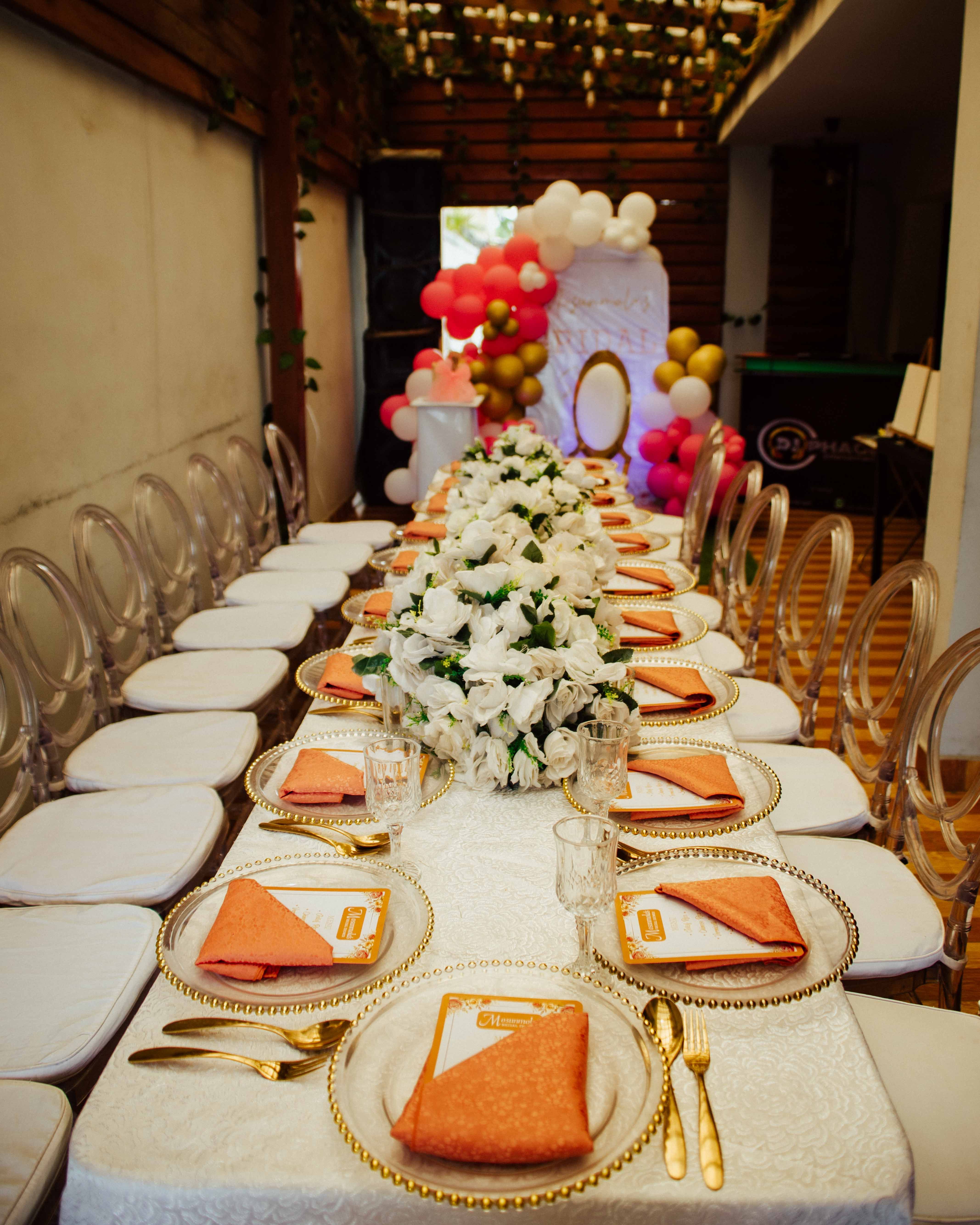 Beautifully decorated indoor banquet table setup with floral centerpiece, ideal for weddings or special events.
