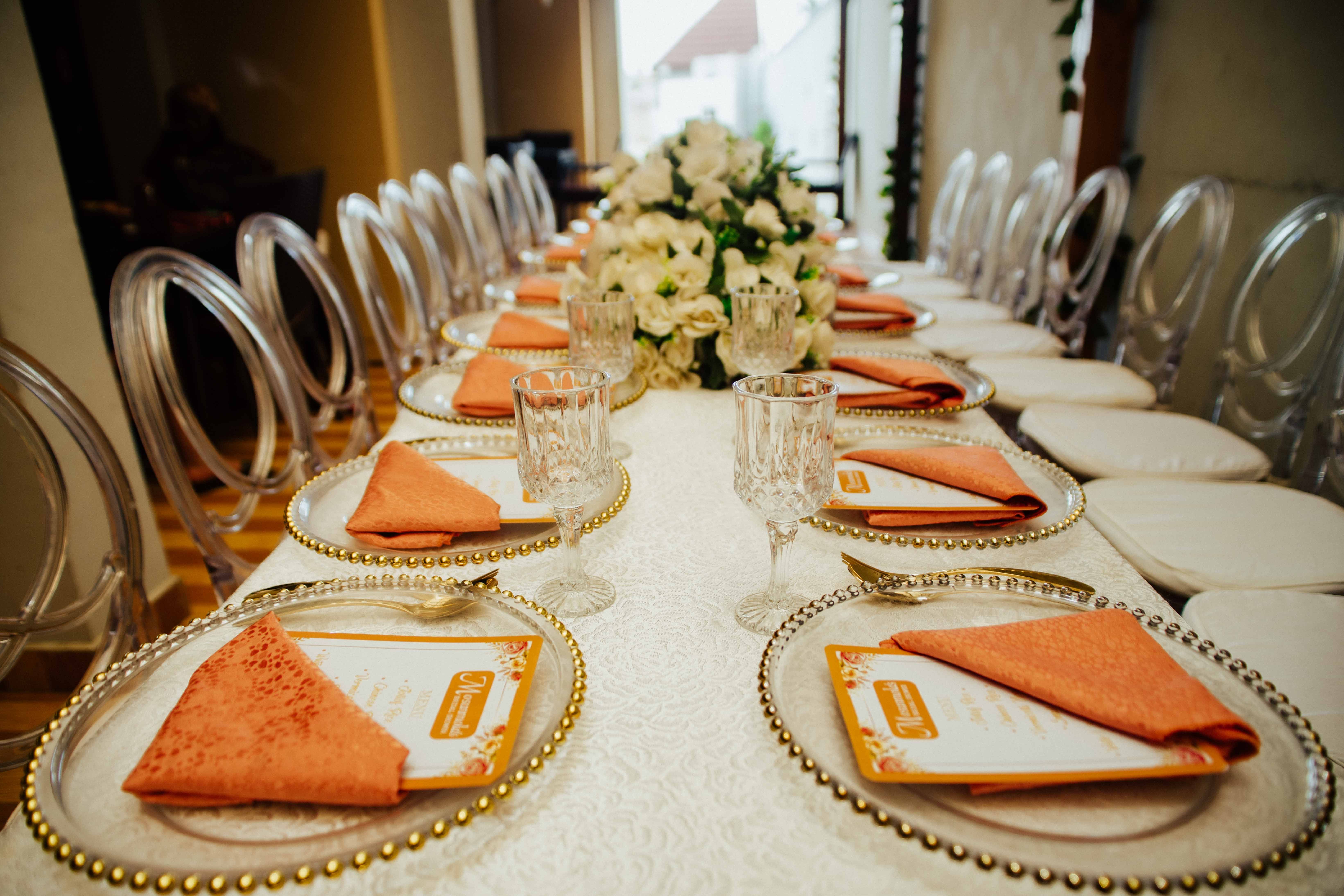 Long dining table arranged for a formal event with elegant decor and place settings.