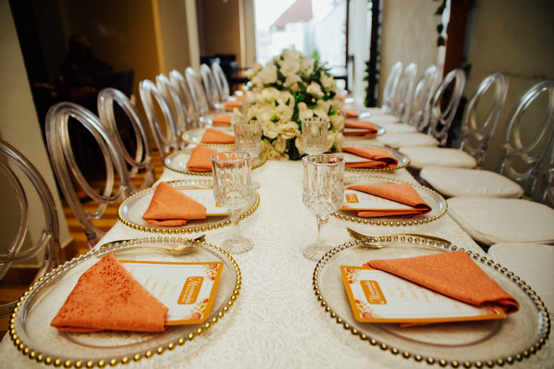 Long dining table arranged for a formal event with elegant decor and place settings.