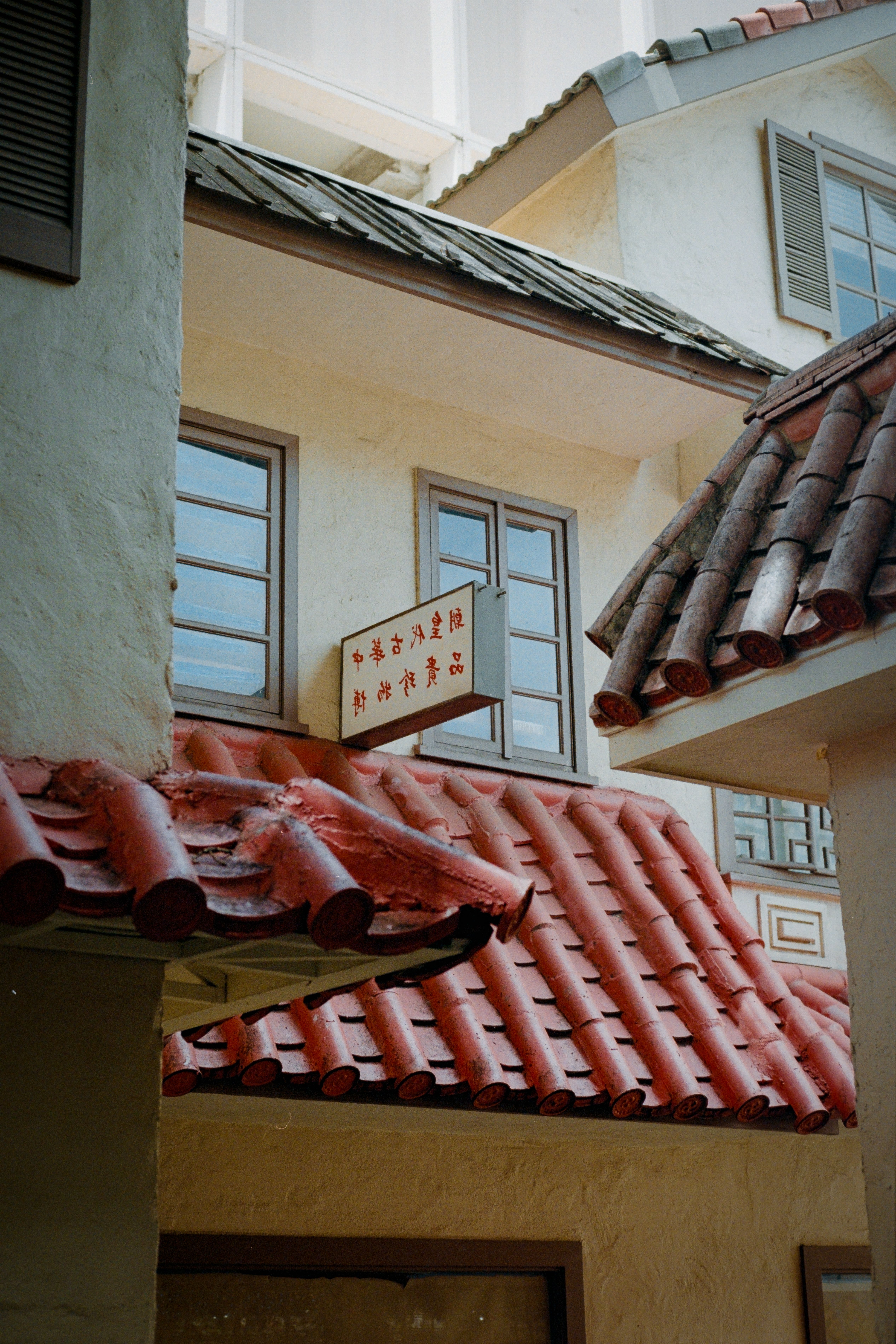 Charming traditional Asian building with distinct red roof tiles and decorative windows.