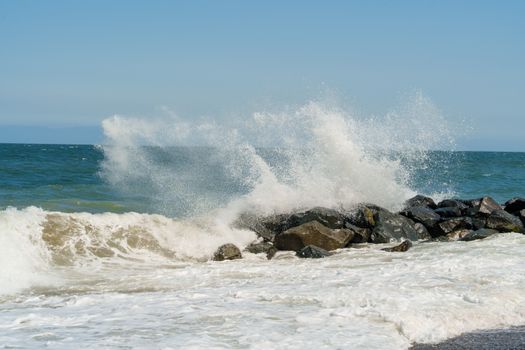 Dynamic ocean waves splashing against a rocky shore.