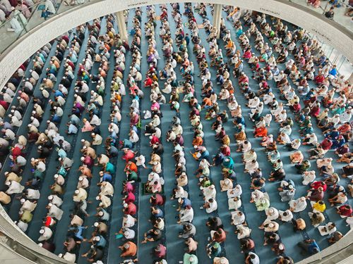 Free Aerial perspective of numerous people attending a prayer session in a mosque. Stock Photo