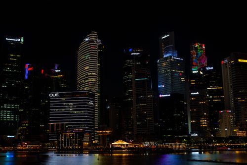 Free Stunning view of Singapore's skyline at night, featuring illuminated skyscrapers reflecting on the water. Stock Photo