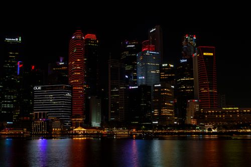 Free Stunning view of illuminated Singapore skyline reflecting on water during nighttime. Stock Photo
