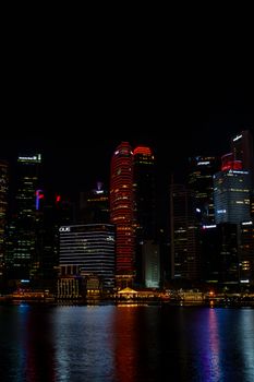 Captivating view of Singapore's illuminated cityscape reflecting on Marina Bay at night.