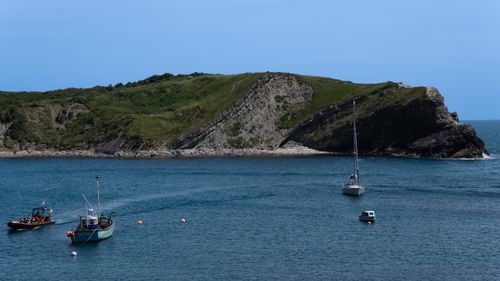 Free Picturesque boats floating in West Lulworth Bay, England, with a stunning rock formation. Stock Photo