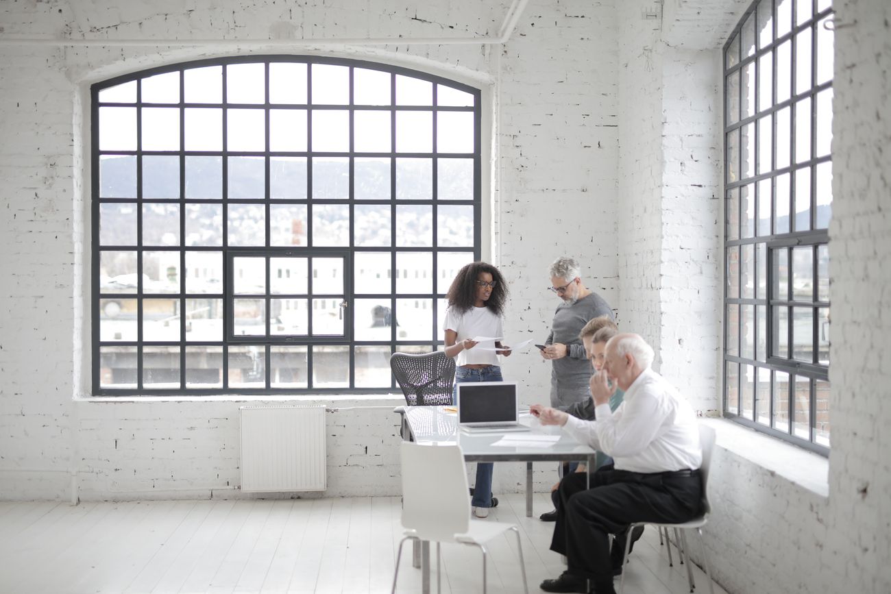 Colleagues working at a table in a daylit loft studio — photo by Andrea Piacquadio on Pexels
