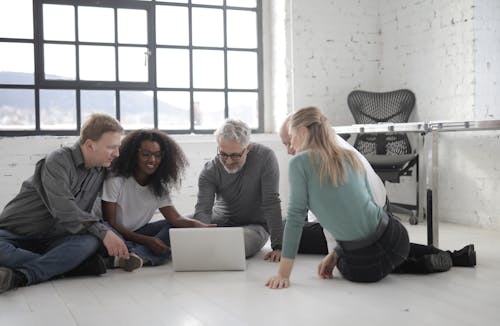 Free Group Of People Working While Seated On The Floor Stock Photo
