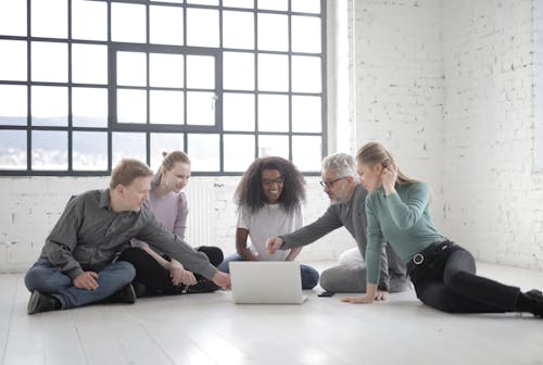 Free Group Of People Having A Discussion While Seated On The Floor Stock Photo