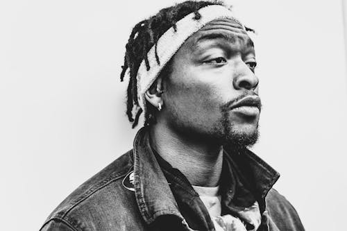 Grayscale Photo Of A Man Wearing Denim Jacket And Headband