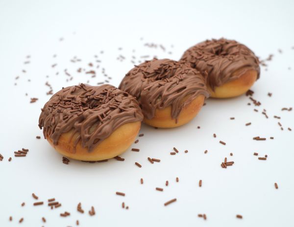 Three chocolate-glazed doughnuts with sprinkles, photo by Sajjad Naqvi on Pexels