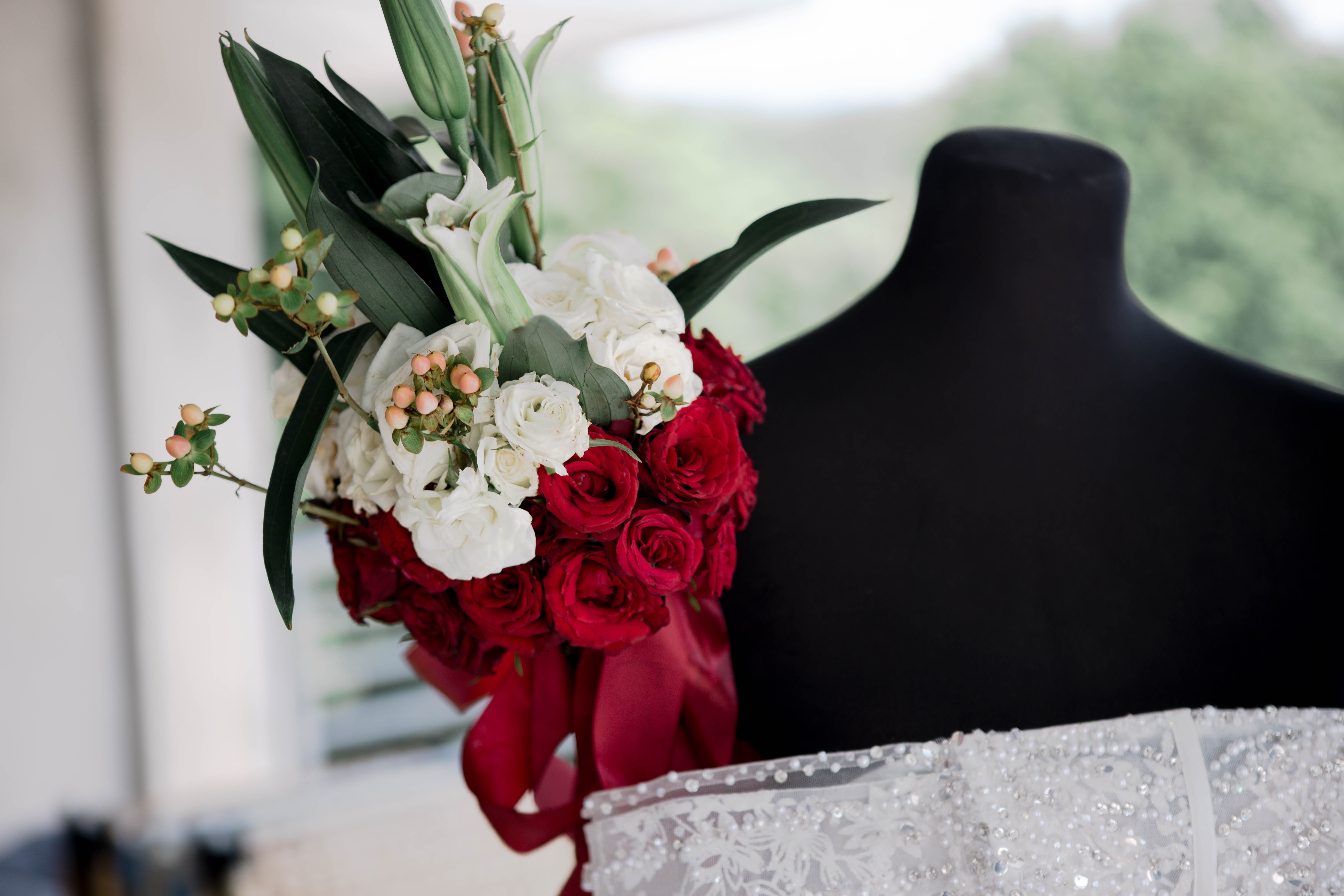 Stunning red and white bridal bouquet displayed on a mannequin, perfect for wedding inspiration.