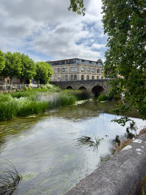 Free Charming view of the river and historic bridge in Bradford-on-Avon, England, surrounded by lush greenery. Stock Photo