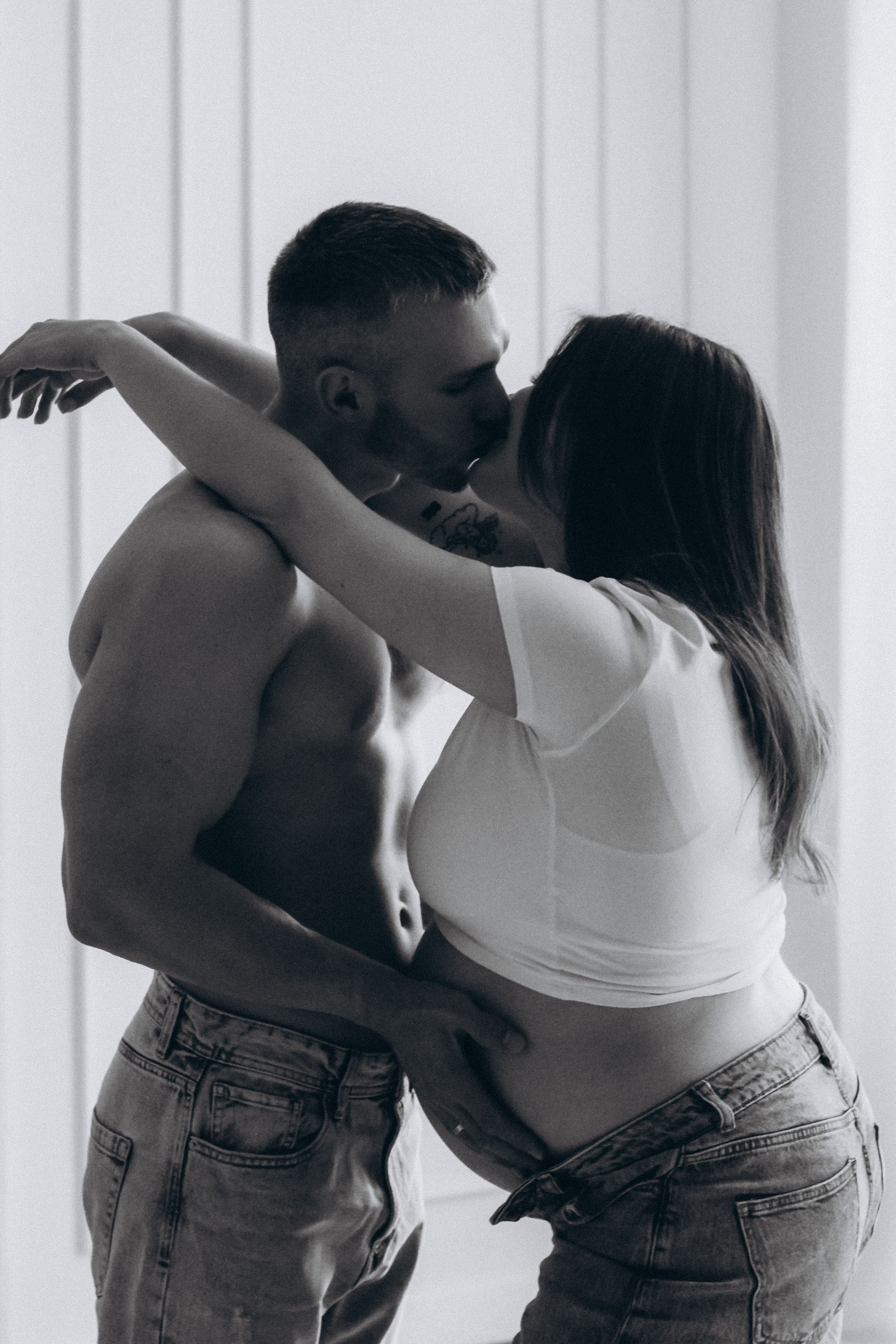 Tender black and white portrait of an intimate kiss between a couple, capturing emotion and connection.