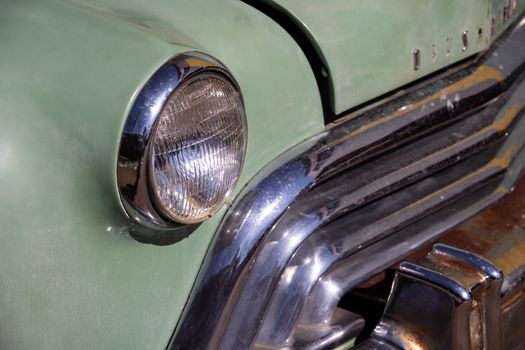 Classic car showcasing a detailed view of its chrome headlight and retro design.
