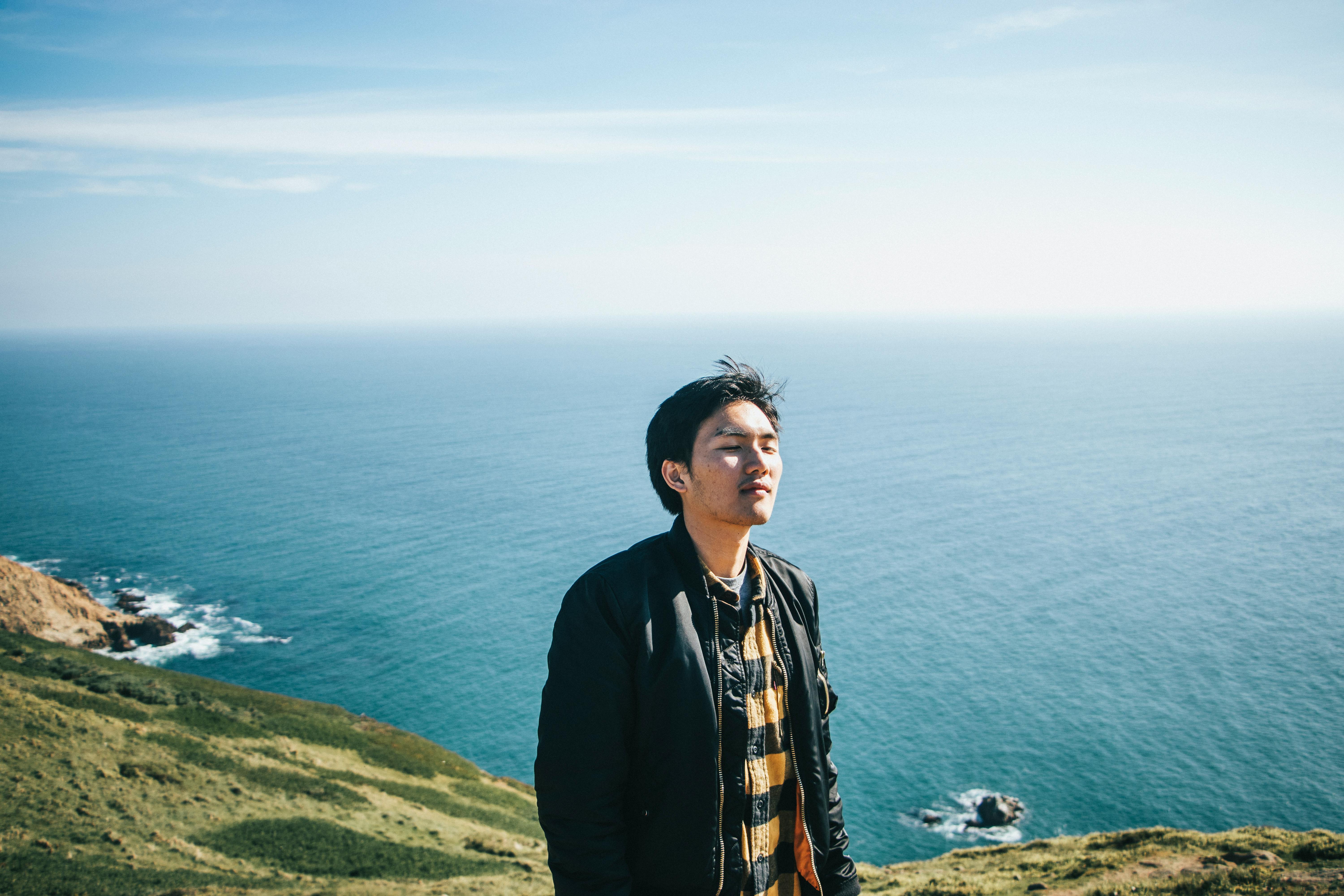 一名男子沐浴着阳光，在海边享受宁静的时刻