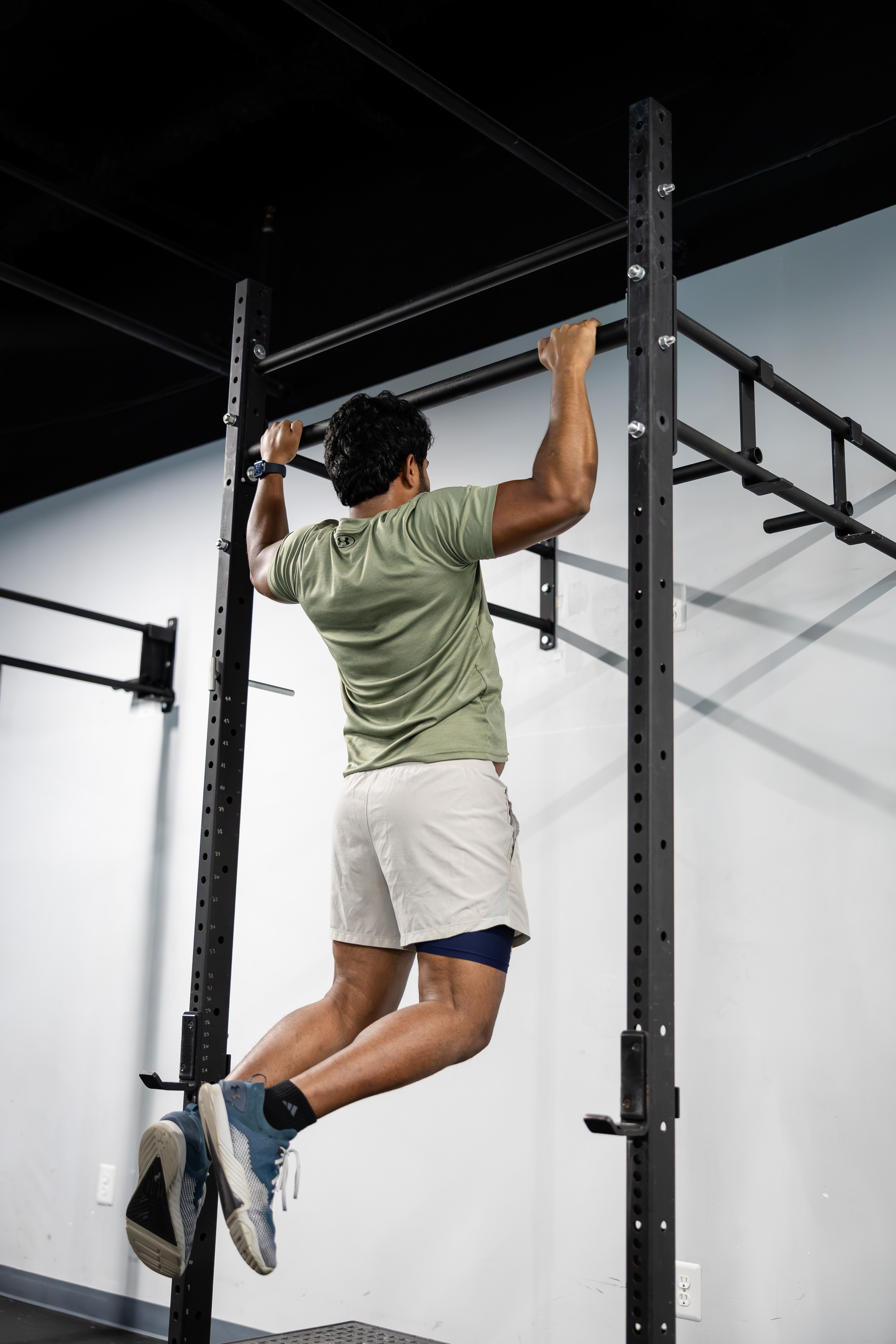 Man performing a pull-up in a modern gym