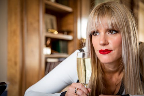 Woman In White Long Sleeve Shirt Holding Champagne Flute