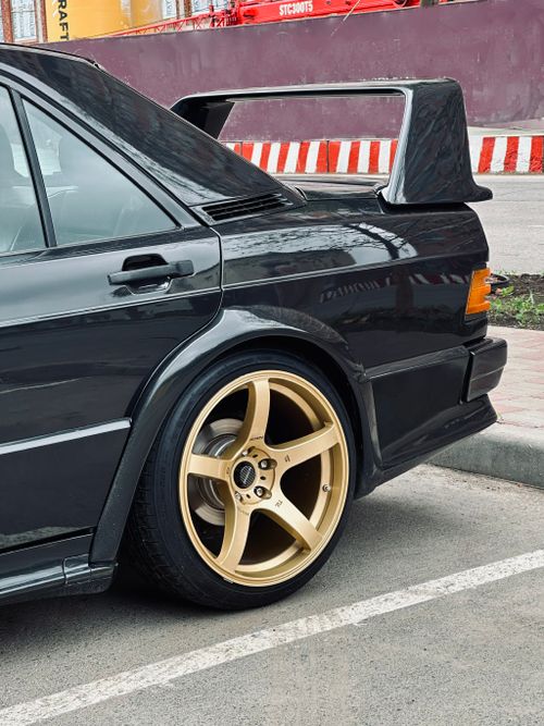 Free Close-up of a black sports car featuring gold rims and aerodynamic spoiler. Stock Photo
