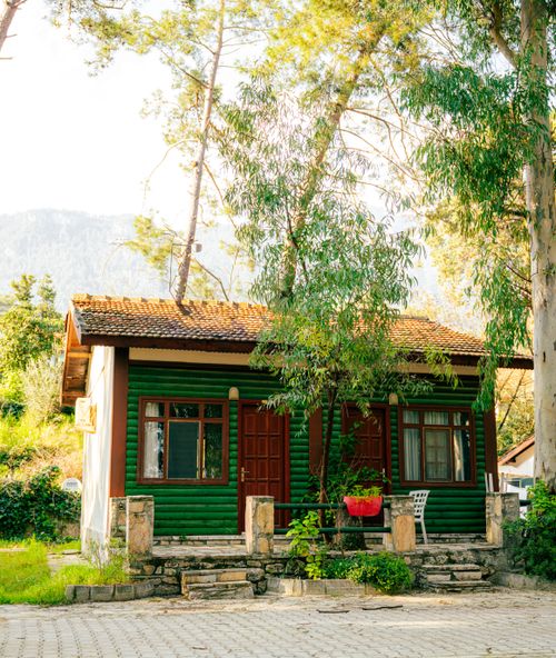 Free Cozy green cabin surrounded by trees in Akyaka, Muğla, Türkiye, offering a serene escape. Stock Photo