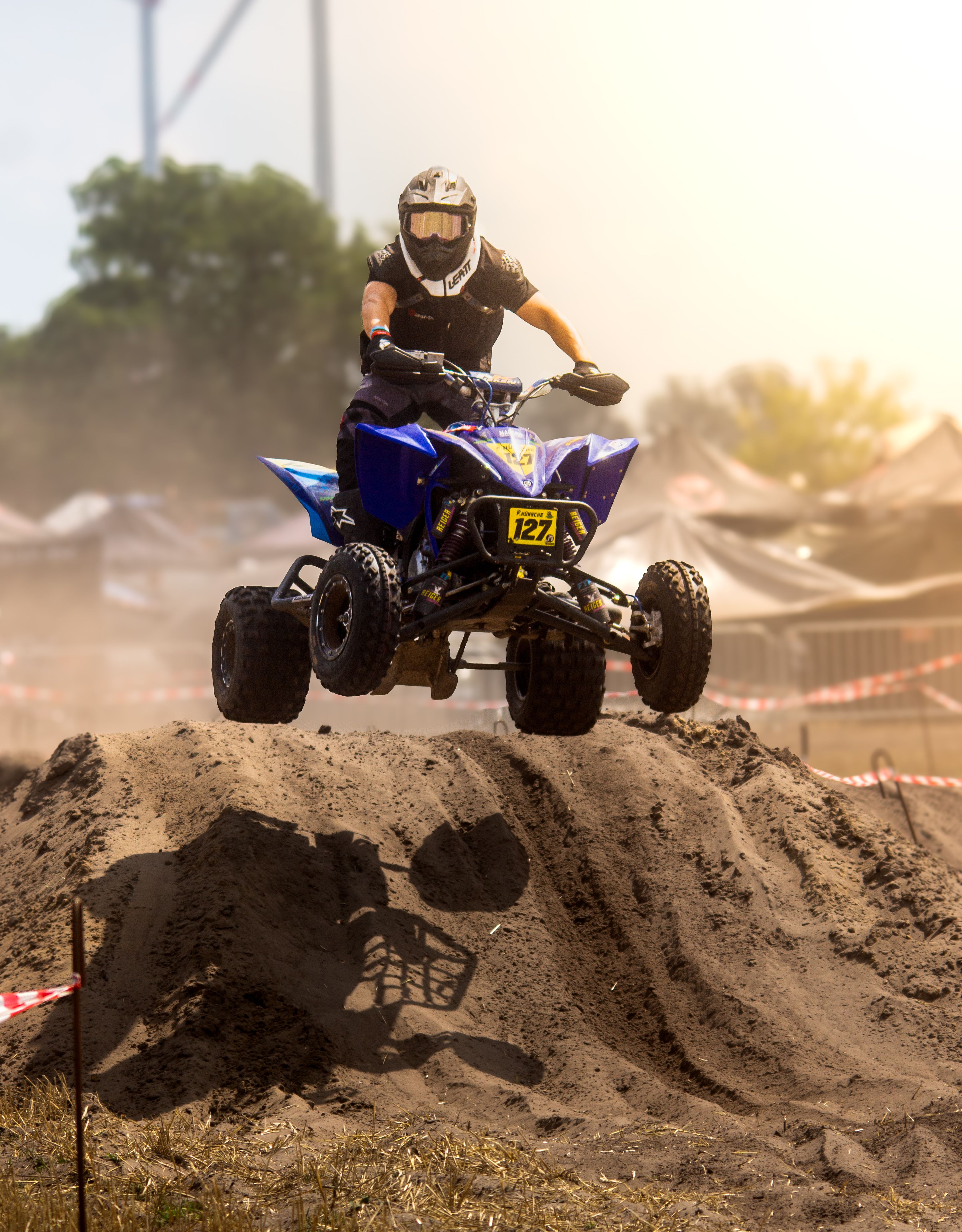High-energy image of an ATV rider airborne during off-road race in Schönwald, Germany.