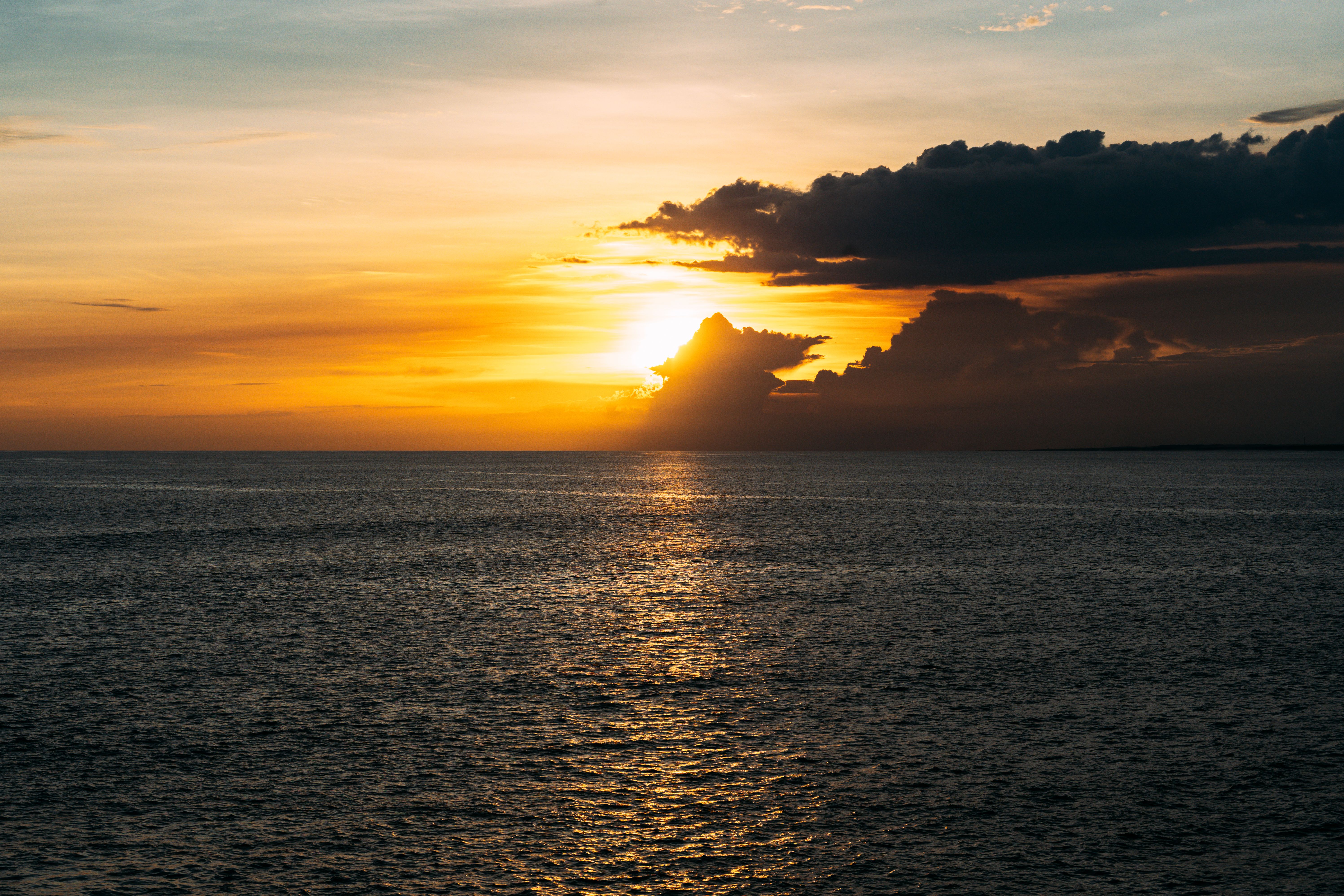 Tourists enjoying a vibrant sunset at Rick's Cafe in Negril, Jamaica, with cliff divers in the background