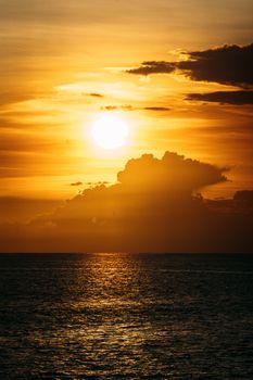 Captivating sunset over the ocean with dramatic clouds and warm golden hues.
