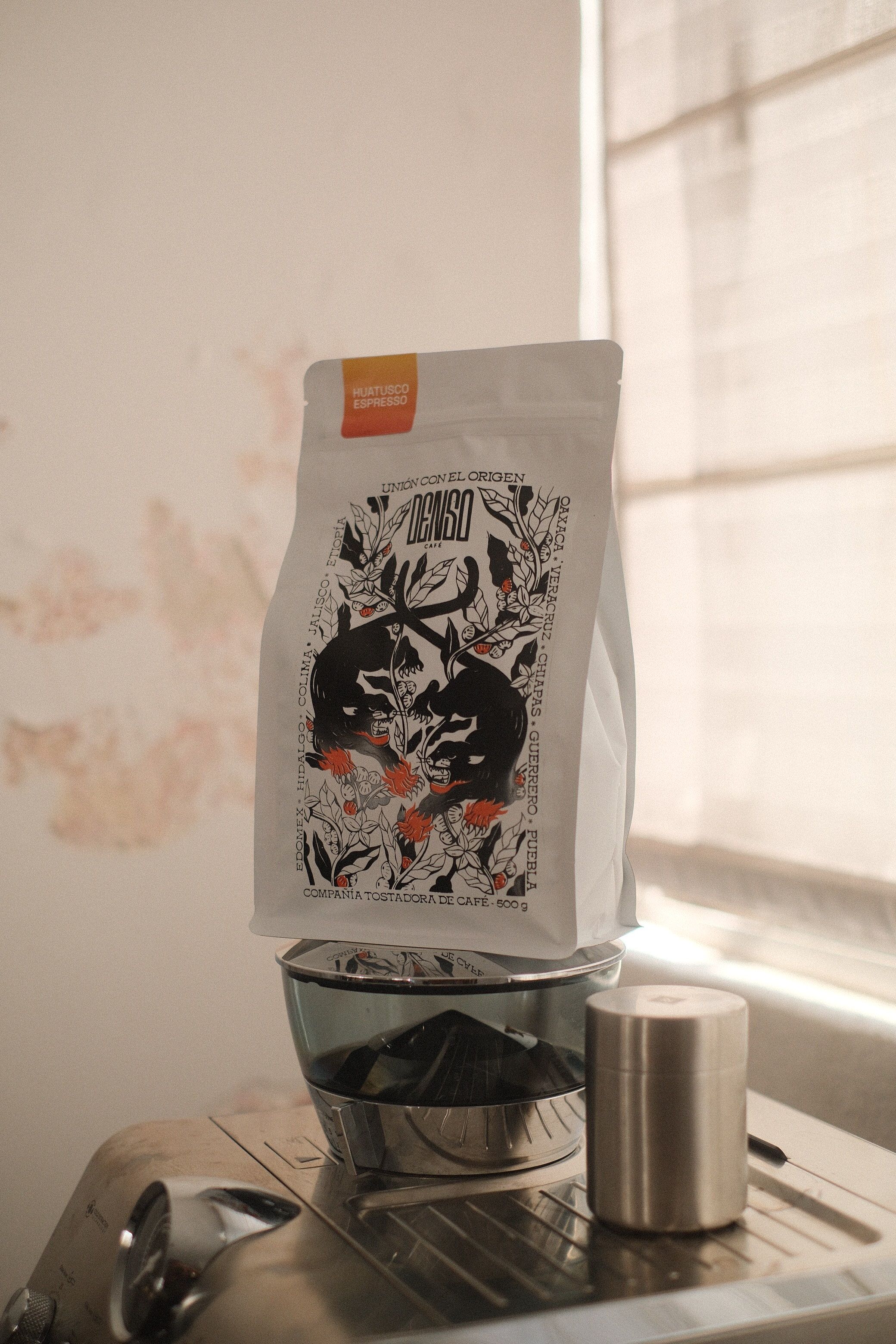 Artisan coffee package on espresso machine in natural light, perfect for cafes and coffee lovers.