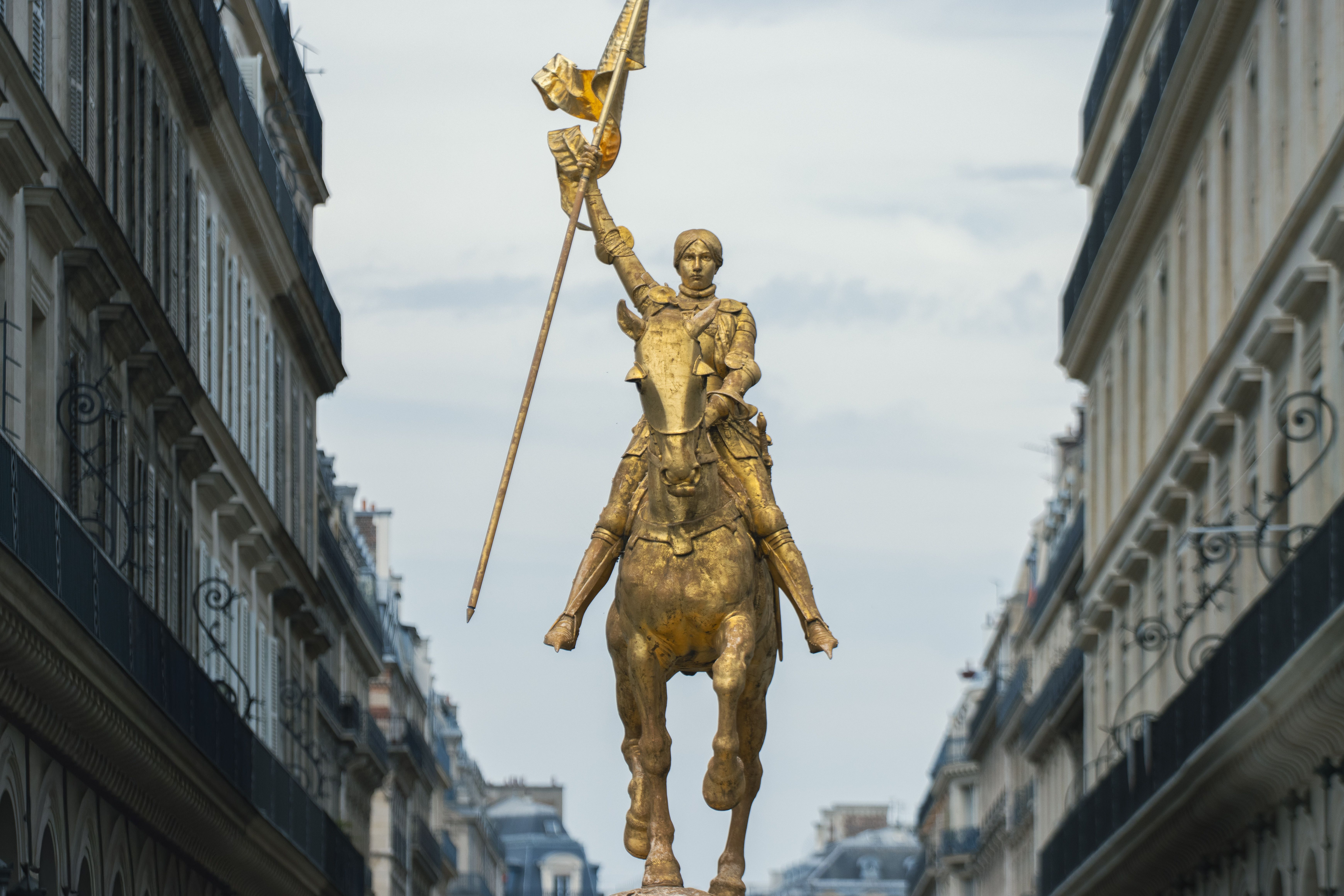 Captivating view of Joan of Arc statue against classic Parisian architecture.