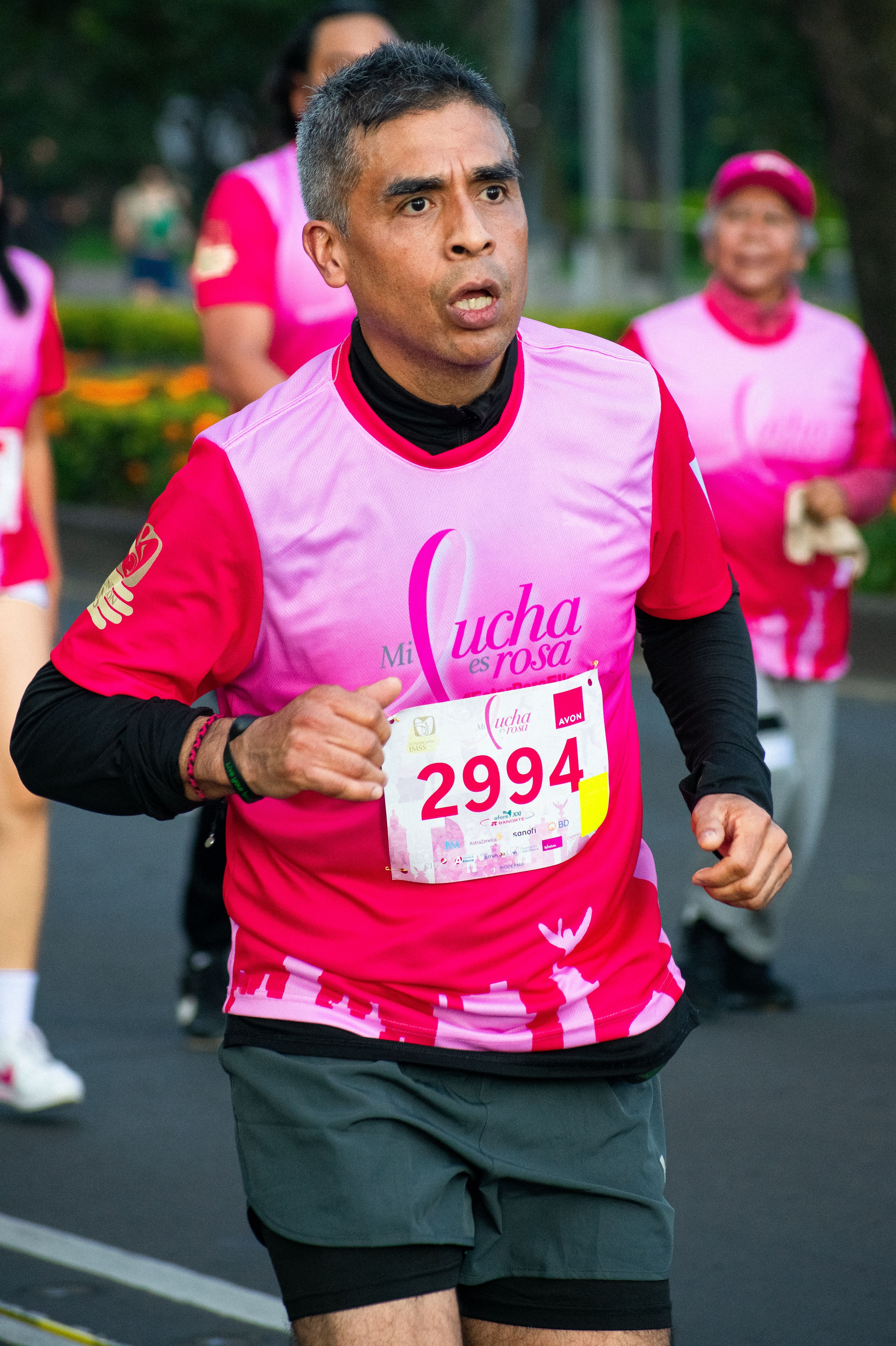 Marathon runner in action during an event in Mexico City, promoting breast cancer awareness.