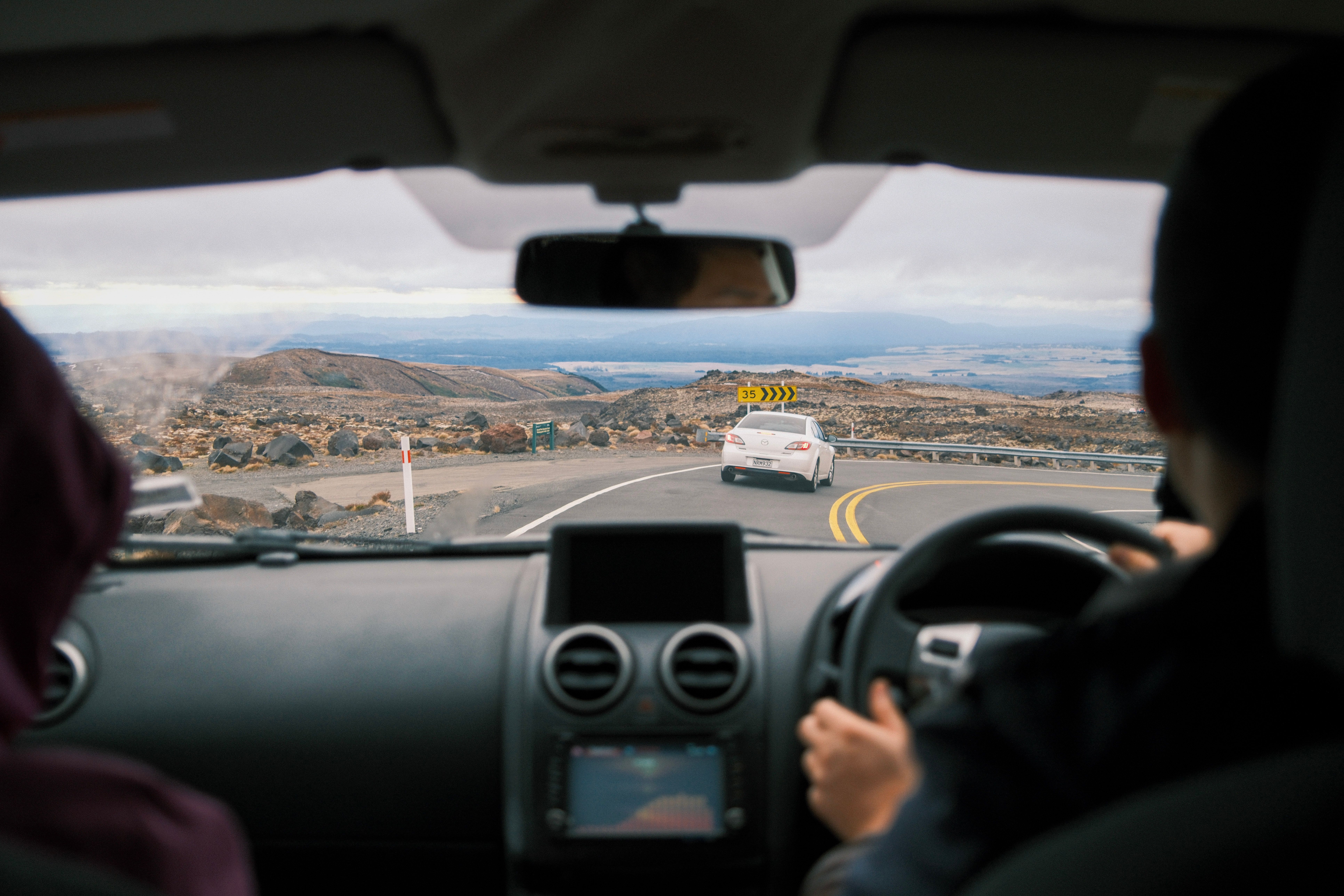 Experience a scenic road trip through New Zealand's winding mountain roads, capturing stunning views.