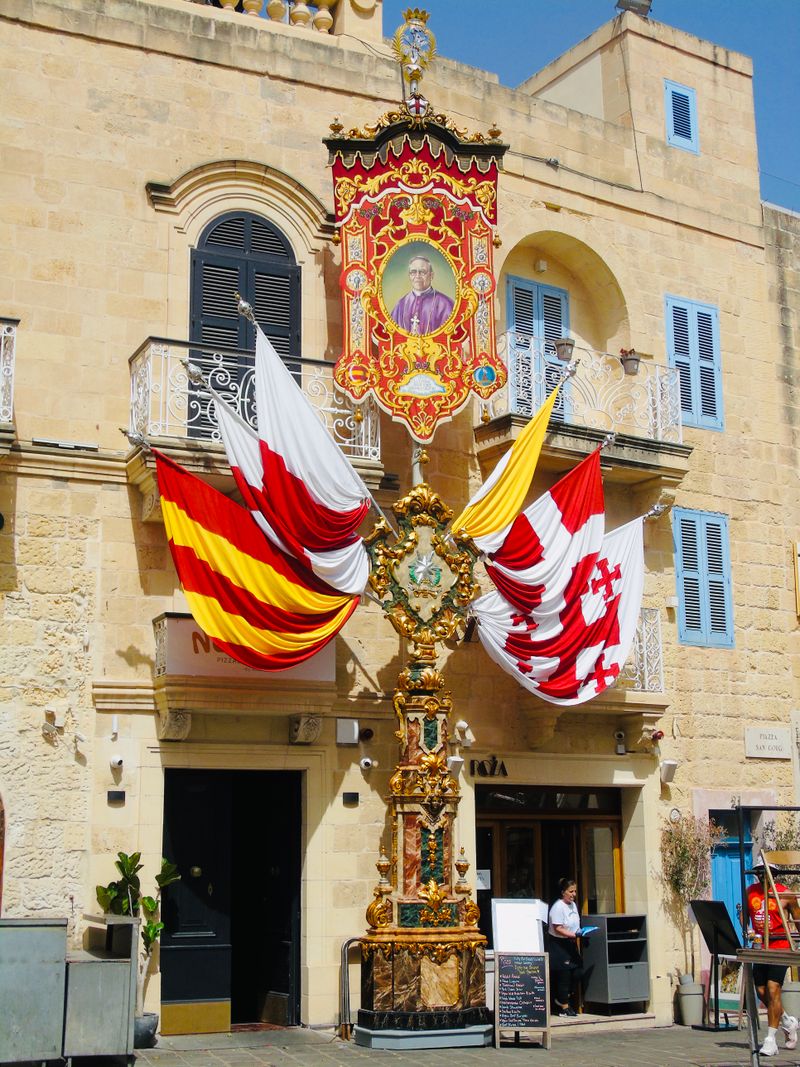 Festive street decorations in a Maltese village with red and white banners