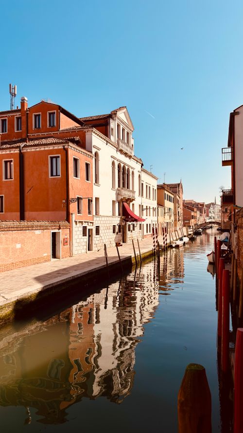 Free Charming canal scene in Venezia, Italy showcasing historic architecture under a clear blue sky. Stock Photo
