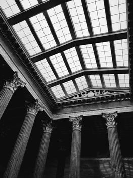 Elegant black and white photo of a classical interior featuring columns and a skylight.