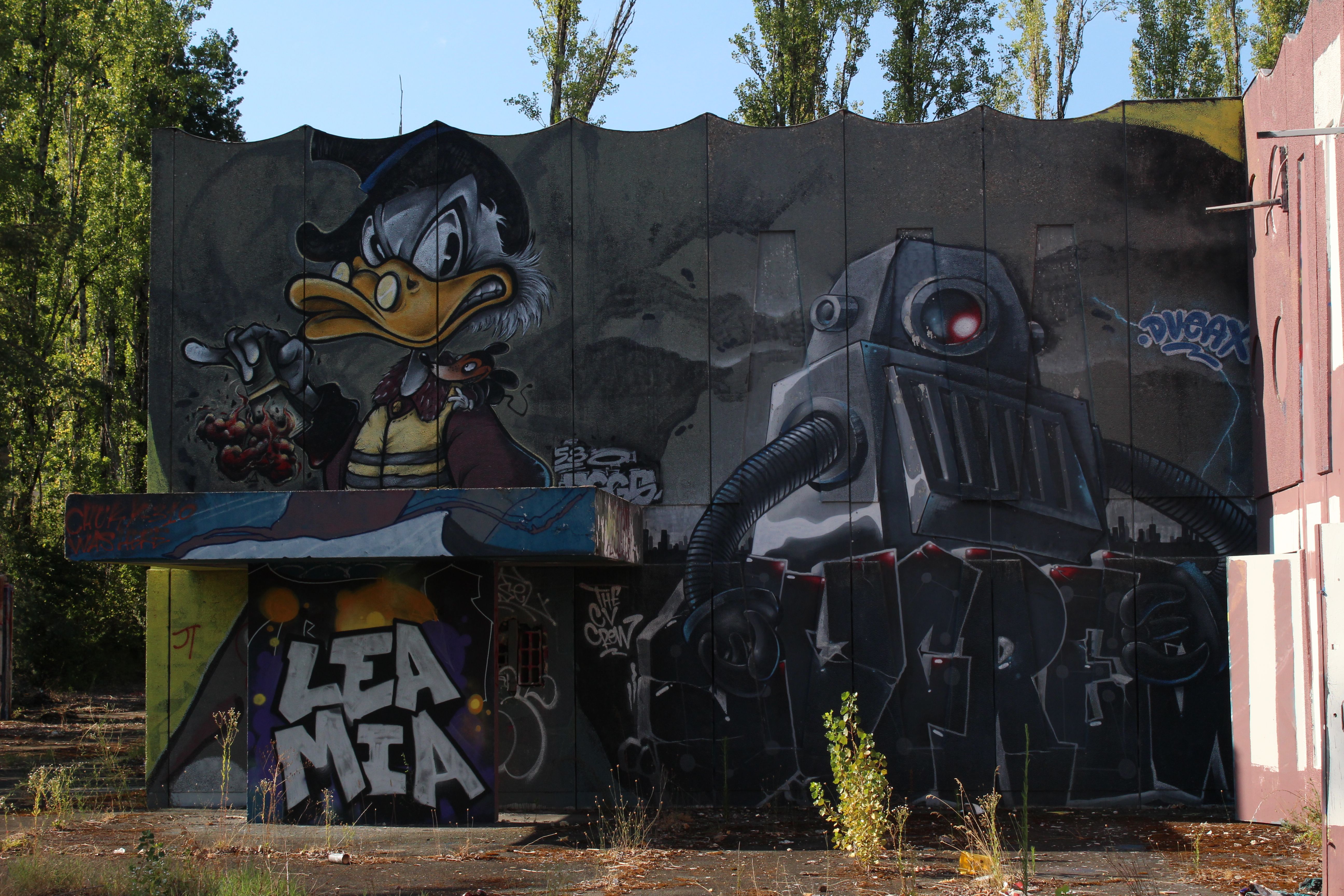 Colorful street art mural showcasing a robot and cartoon duck character in an urban setting.