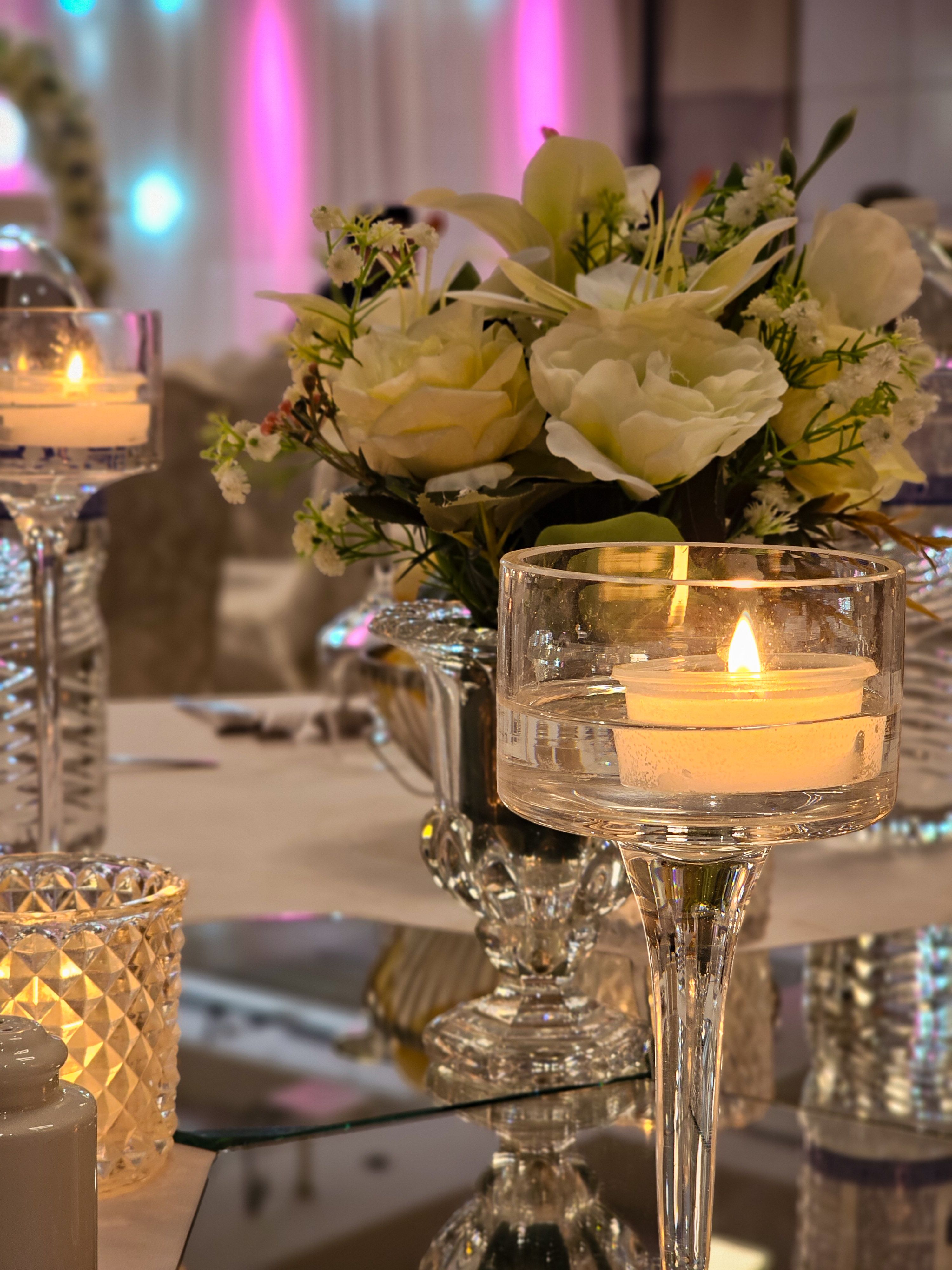 A wedding reception lit by candlelight in a dark room