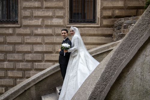 Free Bride and groom in formal attire on an ornate staircase, perfect for wedding inspiration. Stock Photo