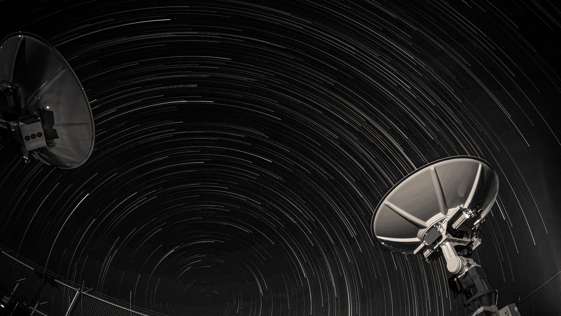 Una gran antena de radiotelescopio apuntando hacia un cielo nocturno estrellado