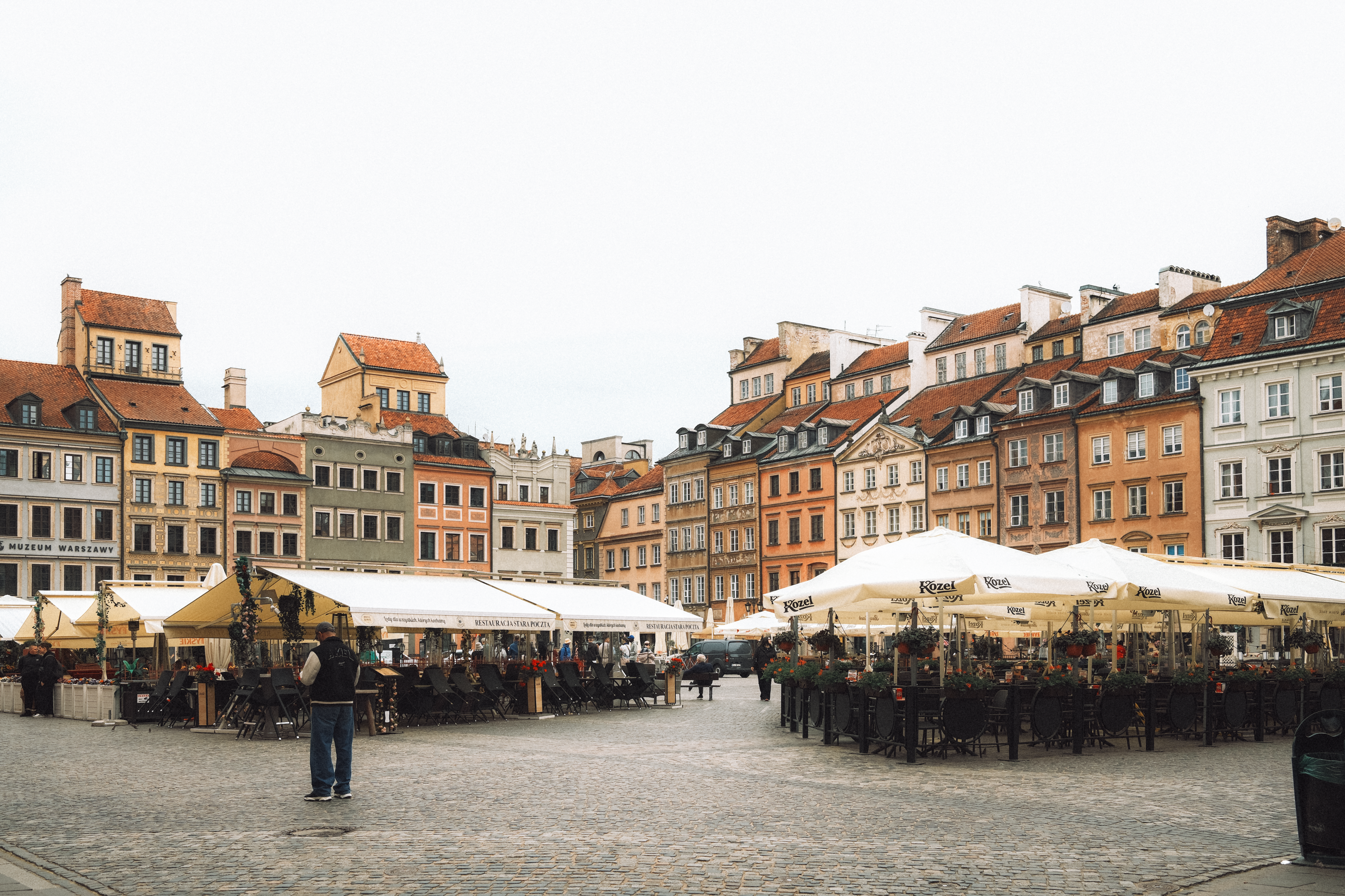 Charming view of colorful tenements and cafes in Warsaw's Old Town Square.