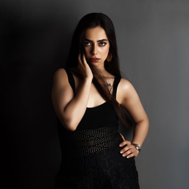 Long column dress against a neutral backdrop — photo by Reza Roshan on Pexels