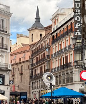 Vibrant street scene in Madrid, showcasing beautiful architecture and bustling city life.