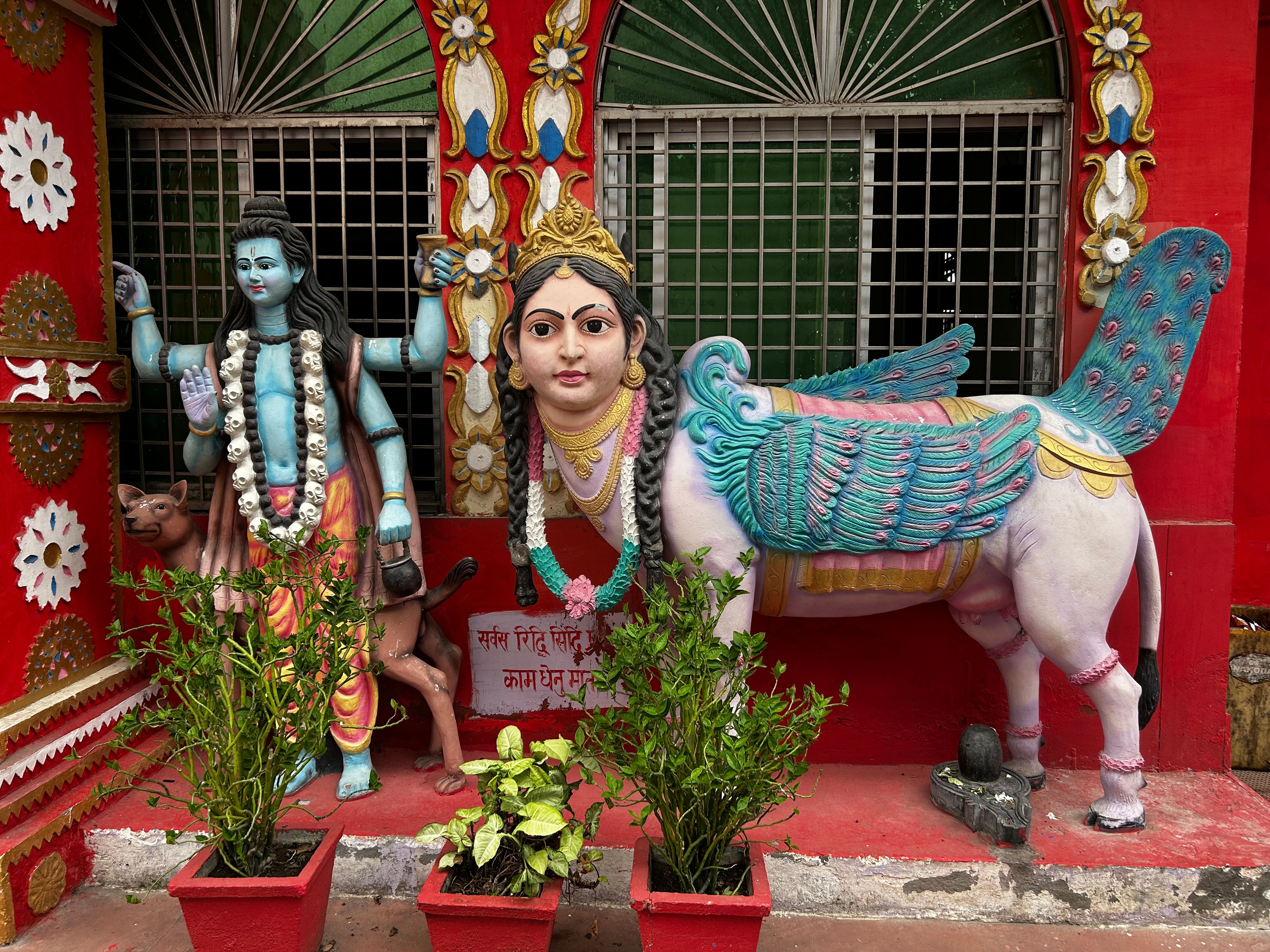 Vibrant statues of Hindu deities at a temple entrance, showcasing cultural art.