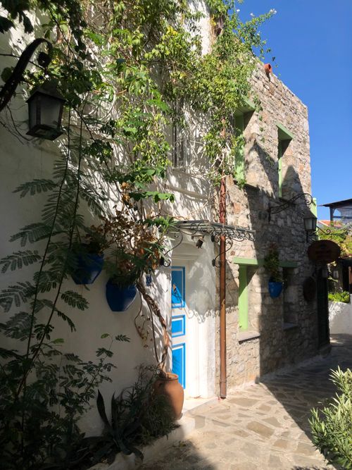 Free Picturesque stone alley in Marmaris with vibrant blue door and lush plants under a clear summer sky. Stock Photo