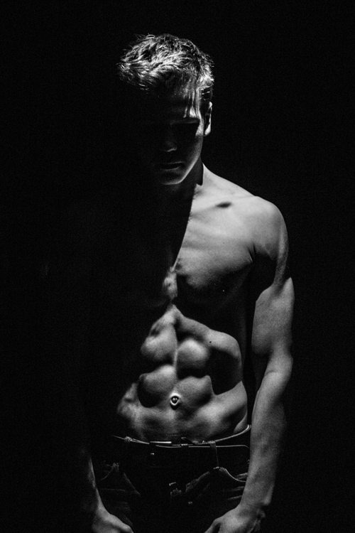 Free Artistic grayscale portrait of a shirtless man emphasizing shadows and muscle definition. Stock Photo