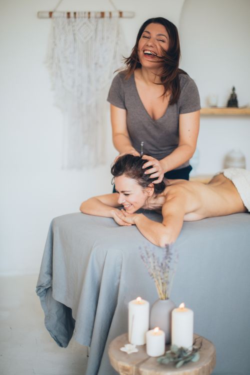 Free Two women enjoying a relaxing massage session in a serene indoor spa setting. Stock Photo