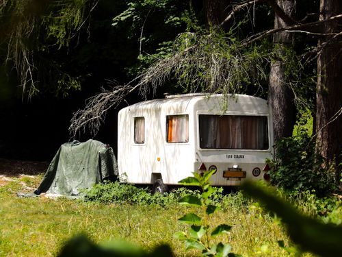 Free A charming Euro-caravan parked in a lush forest setting, Trentino-Alto Adige, Italy. Stock Photo