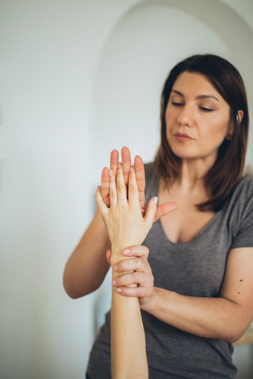 A Woman in Gray Shirt Holding a Person's Hand