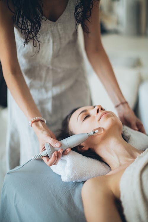 Free A Woman Lying Down with a Laser Device on Her Face Stock Photo