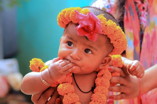 Free Charming baby with colorful floral garland exuding innocence and joy. Stock Photo