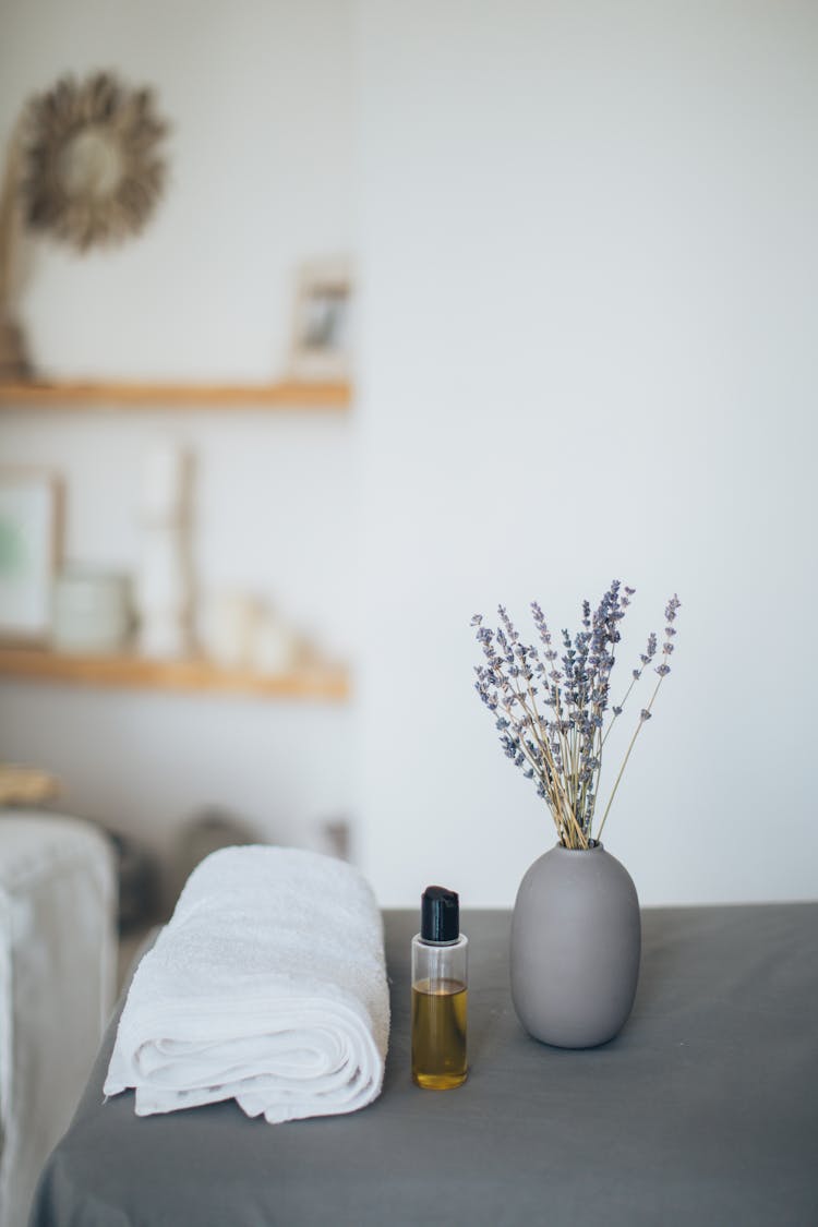 A Lavender Near The Bottle With Oil And A Bath Towel